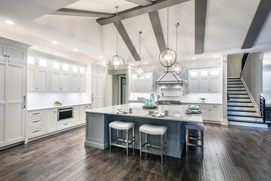 Inspiration for a huge modern l-shaped dark wood floor and brown floor open concept kitchen remodel in Other with an undermount sink, recessed-panel cabinets, white cabinets, marble countertops, white backsplash, glass tile backsplash, paneled appliances, an island and white countertops