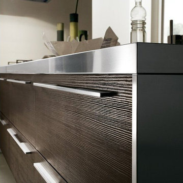 Modern dark wood kitchen with stainless steel counter and white cabinets
