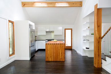 アトランタにあるコンテンポラリースタイルのおしゃれなL型キッチン (フラットパネル扉のキャビネット、白いキャビネット、白いキッチンパネル、サブウェイタイルのキッチンパネル、シルバーの調理設備) の写真