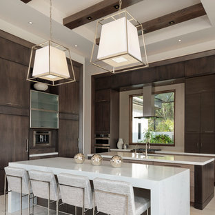 Esempio di una grande cucina a L minimalista con ante lisce, ante in legno bruno, elettrodomestici da incasso, 2 o più isole, top bianco, lavello sottopiano, pavimento in gres porcellanato e pavimento beige