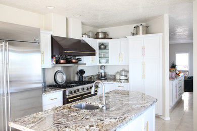 Foto på ett mellanstort vintage kök, med en undermonterad diskho, luckor med infälld panel, vita skåp, marmorbänkskiva, flerfärgad stänkskydd, stänkskydd i marmor, rostfria vitvaror, klinkergolv i keramik, en köksö och beiget golv