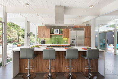 Mid-sized trendy galley porcelain tile, gray floor and exposed beam eat-in kitchen photo in Nashville with an undermount sink, flat-panel cabinets, medium tone wood cabinets, quartz countertops, green backsplash, glass tile backsplash, stainless steel appliances, an island and white countertops