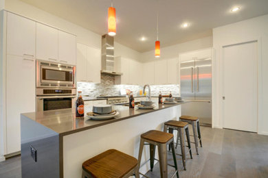 Example of a large minimalist l-shaped ceramic tile and brown floor eat-in kitchen design in Austin with an undermount sink, flat-panel cabinets, white cabinets, quartz countertops, multicolored backsplash, ceramic backsplash, stainless steel appliances, an island and gray countertops