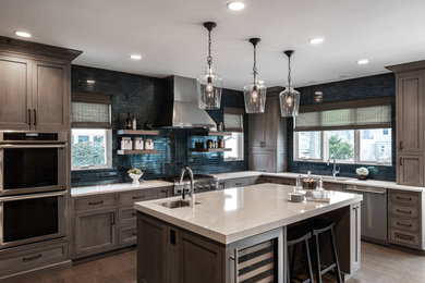 Example of a large country l-shaped medium tone wood floor and brown floor eat-in kitchen design in Chicago with a single-bowl sink, medium tone wood cabinets, quartz countertops, blue backsplash, stainless steel appliances, an island, gray countertops, recessed-panel cabinets and cement tile backsplash