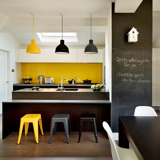 Mid-sized contemporary galley eat-in kitchen in Other with flat-panel cabinets, white cabinets, yellow splashback, dark hardwood floors, grey benchtop, a double-bowl sink, glass sheet splashback, a peninsula and brown floor.
