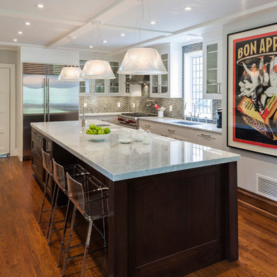 Kitchen - transitional l-shaped kitchen idea in New York with an undermount sink, glass-front cabinets, white cabinets, gray backsplash and stainless steel appliances