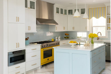 Modelo de cocina minimalista grande con salpicadero azul, electrodomésticos de colores, una isla y suelo gris