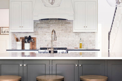 Eat-in kitchen - large farmhouse galley brown floor eat-in kitchen idea in Minneapolis with a farmhouse sink, beaded inset cabinets, white cabinets, quartz countertops, multicolored backsplash, an island and white countertops