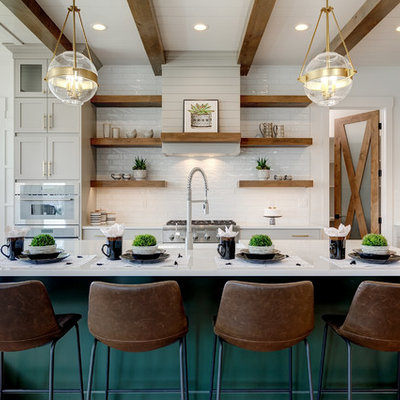 Open concept kitchen - large farmhouse l-shaped light wood floor and beige floor open concept kitchen idea in Boise with a farmhouse sink, shaker cabinets, white backsplash, subway tile backsplash, stainless steel appliances, an island, white countertops, white cabinets and quartz countertops