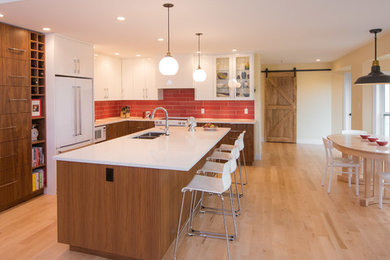 1960s light wood floor eat-in kitchen photo in Vancouver with a double-bowl sink, flat-panel cabinets, medium tone wood cabinets, quartz countertops, red backsplash, ceramic backsplash, white appliances and an island