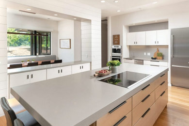Large minimalist u-shaped light wood floor and beige floor eat-in kitchen photo in Other with a farmhouse sink, flat-panel cabinets, white cabinets, quartz countertops, stainless steel appliances, an island and gray countertops