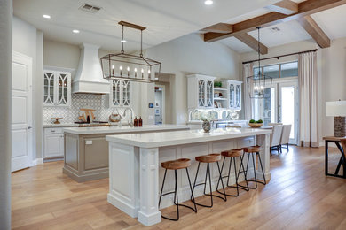 Example of a huge farmhouse kitchen design in Phoenix with glass-front cabinets, white cabinets, quartzite countertops and two islands