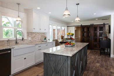 Mid-sized country dark wood floor and brown floor eat-in kitchen photo in Other with a farmhouse sink, shaker cabinets, white cabinets, granite countertops, beige backsplash, stone tile backsplash and an island