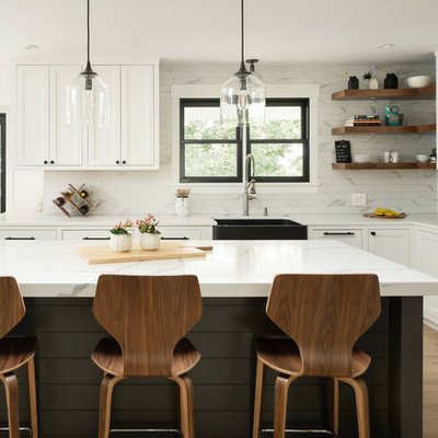 Transitional l-shaped medium tone wood floor open concept kitchen photo in Denver with a farmhouse sink, shaker cabinets, white cabinets, quartz countertops, porcelain backsplash, stainless steel appliances, an island and white countertops
