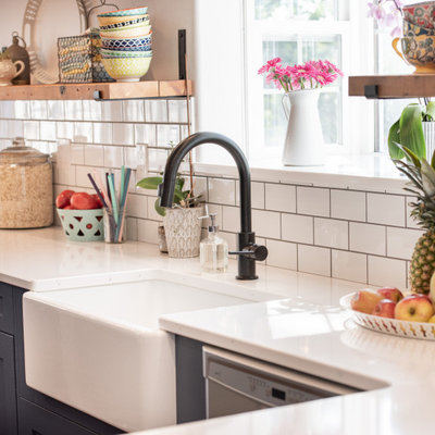 Large cottage u-shaped medium tone wood floor and brown floor eat-in kitchen photo in Other with a farmhouse sink, recessed-panel cabinets, blue cabinets, quartz countertops, white backsplash, subway tile backsplash, stainless steel appliances, a peninsula and white countertops