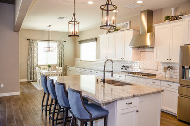 Large cottage ceramic tile and brown floor eat-in kitchen photo in Other with an undermount sink, recessed-panel cabinets, white cabinets, granite countertops, white backsplash, subway tile backsplash, stainless steel appliances and an island