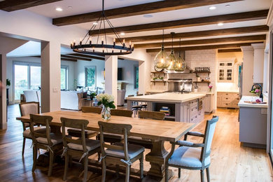 Example of a large country l-shaped medium tone wood floor and beige floor eat-in kitchen design in San Francisco with a farmhouse sink, shaker cabinets, gray cabinets, concrete countertops, gray backsplash, subway tile backsplash, stainless steel appliances, an island and beige countertops