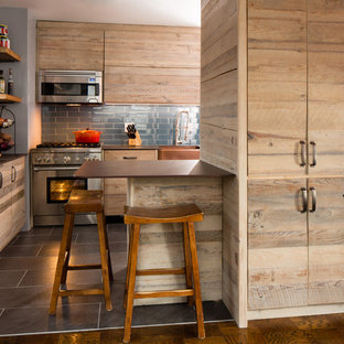 This is an example of a small transitional u-shaped eat-in kitchen in New York with a farmhouse sink, flat-panel cabinets, light wood cabinets, stainless steel appliances, ceramic floors, quartz benchtops, blue splashback, glass tile splashback and a peninsula.