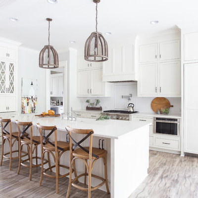 Kitchen - country u-shaped kitchen idea in Nashville with shaker cabinets, white cabinets, white appliances, an island and white countertops