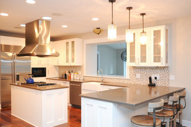 Transitional u-shaped kitchen photo in St Louis with a farmhouse sink, shaker cabinets, white cabinets, multicolored backsplash and stainless steel appliances
