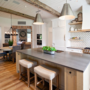 Farmhouse open concept kitchen designs - Inspiration for a cottage medium tone wood floor open concept kitchen remodel in Phoenix with an undermount sink, recessed-panel cabinets, white cabinets, multicolored backsplash, stainless steel appliances, an island and gray countertops