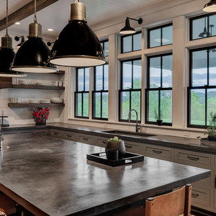Idee per un grande cucina con isola centrale country con lavello a vasca singola, ante in stile shaker, ante grigie, top in cemento, paraspruzzi bianco, paraspruzzi in legno, elettrodomestici in acciaio inossidabile, parquet scuro, pavimento marrone e top nero