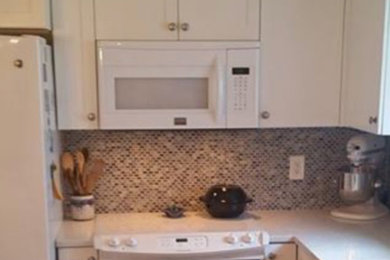 Mid-sized beach style u-shaped eat-in kitchen photo in Atlanta with an undermount sink, recessed-panel cabinets, white cabinets, marble countertops, blue backsplash, mosaic tile backsplash, white appliances and an island