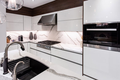 Mid-sized minimalist l-shaped kitchen photo in Toronto with flat-panel cabinets, white cabinets, white backsplash, stainless steel appliances, an island and white countertops