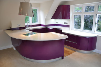 Inspiration for a medium sized contemporary u-shaped open plan kitchen in Kent with a built-in sink, flat-panel cabinets, purple cabinets, quartz worktops, glass sheet splashback, black appliances, light hardwood flooring, a breakfast bar, brown floors and white worktops.