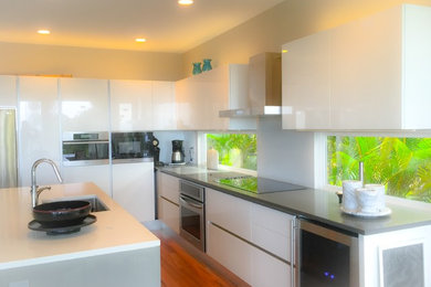 Example of a mid-sized minimalist dark wood floor eat-in kitchen design in Hawaii with an undermount sink, white cabinets, quartz countertops, stainless steel appliances, glass-front cabinets and an island