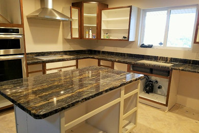 Kitchen - mid-sized transitional u-shaped ceramic tile kitchen idea in Salt Lake City with a double-bowl sink, dark wood cabinets, granite countertops, stainless steel appliances and an island