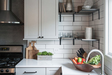 Eat-in kitchen - mid-sized industrial u-shaped light wood floor and beige floor eat-in kitchen idea in Chicago with a farmhouse sink, shaker cabinets, gray cabinets, quartz countertops, white backsplash, ceramic backsplash, stainless steel appliances, an island and gray countertops