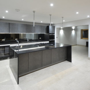 Foto di un'ampia cucina minimalista con lavello a doppia vasca, ante lisce, ante grigie, top in granito, paraspruzzi a effetto metallico, paraspruzzi a specchio, elettrodomestici in acciaio inossidabile, pavimento in pietra calcarea e isola