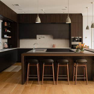 Contemporary kitchen designs - Trendy u-shaped medium tone wood floor and brown floor kitchen photo in New York with flat-panel cabinets, brown cabinets, beige backsplash, an island and brown countertops
