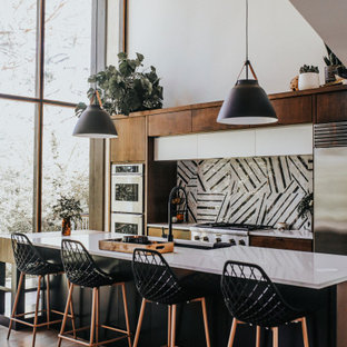 Contemporary kitchen ideas - Trendy galley light wood floor and beige floor kitchen photo in Seattle with an undermount sink, flat-panel cabinets, dark wood cabinets, multicolored backsplash, stainless steel appliances, an island and white countertops