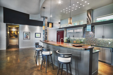 Large minimalist galley concrete floor open concept kitchen photo in Dallas with raised-panel cabinets, gray cabinets, wood countertops, multicolored backsplash, glass tile backsplash, colored appliances and an island