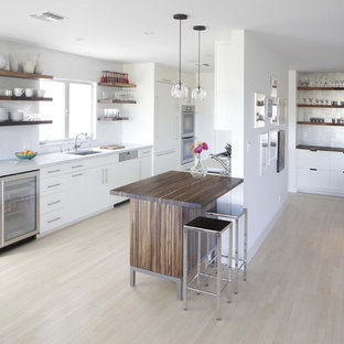 Modern galley open plan kitchen in Birmingham with panelled appliances, open cabinets and white cabinets.