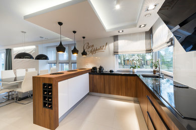 Photo of a medium sized contemporary l-shaped open plan kitchen in Los Angeles with a submerged sink, flat-panel cabinets, dark wood cabinets, wood worktops, white splashback, glass sheet splashback, stainless steel appliances, ceramic flooring, an island and white floors.
