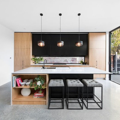 Kitchen - contemporary galley concrete floor kitchen idea in Melbourne with black cabinets, quartz countertops, an island, an undermount sink, flat-panel cabinets and paneled appliances