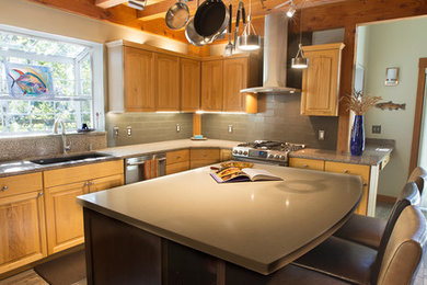 Example of a large arts and crafts u-shaped laminate floor and brown floor open concept kitchen design in Other with an undermount sink, raised-panel cabinets, light wood cabinets, terrazzo countertops, gray backsplash, ceramic backsplash, stainless steel appliances and an island