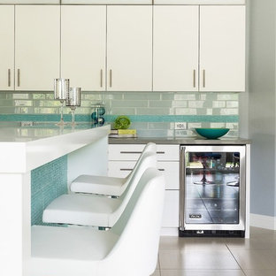 Large contemporary eat-in kitchen photos - Large trendy l-shaped ceramic tile eat-in kitchen photo in Los Angeles with an undermount sink, flat-panel cabinets, white cabinets, solid surface countertops, white backsplash, subway tile backsplash, stainless steel appliances and an island