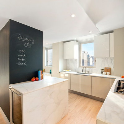 Minimalist kitchen photo in New York with flat-panel cabinets, white cabinets and white backsplash