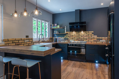 Photo of a medium sized modern u-shaped kitchen/diner in London with black cabinets.
