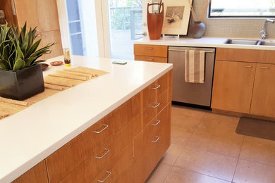 Diseño de cocinas en L minimalista de tamaño medio cerrada con armarios con paneles lisos, puertas de armario de madera clara y una isla