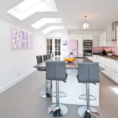 Inspiration for a contemporary l-shaped kitchen remodel in Surrey with an undermount sink, flat-panel cabinets, white cabinets, pink backsplash, glass sheet backsplash, colored appliances and an island