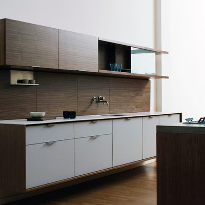 Example of a minimalist galley kitchen design in New York with solid surface countertops, an undermount sink, flat-panel cabinets, white cabinets and brown backsplash