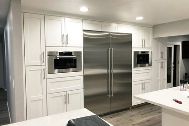 Kitchen - modern kitchen idea in San Francisco with white cabinets, marble countertops and an island