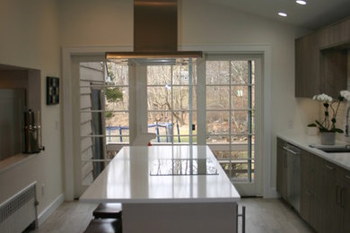 Example of a mid-sized minimalist single-wall porcelain tile eat-in kitchen design in New York with an undermount sink, flat-panel cabinets, gray cabinets, quartz countertops, gray backsplash, glass tile backsplash, stainless steel appliances and an island