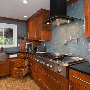 Imagen de cocina comedor en L, moderna, grande, con fregadero sobremueble, armarios estilo shaker, puertas de armario de madera oscura, encimera de cuarzo compacto, salpicadero verde, electrodomésticos de acero inoxidable, suelo de corcho, una isla y salpicadero de azulejos de vidrio
