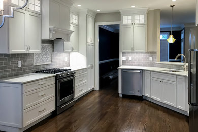 Inspiration for a mid-sized contemporary u-shaped dark wood floor and brown floor enclosed kitchen remodel in Wilmington with an undermount sink, shaker cabinets, white cabinets, quartzite countertops, gray backsplash, subway tile backsplash, stainless steel appliances, no island and white countertops